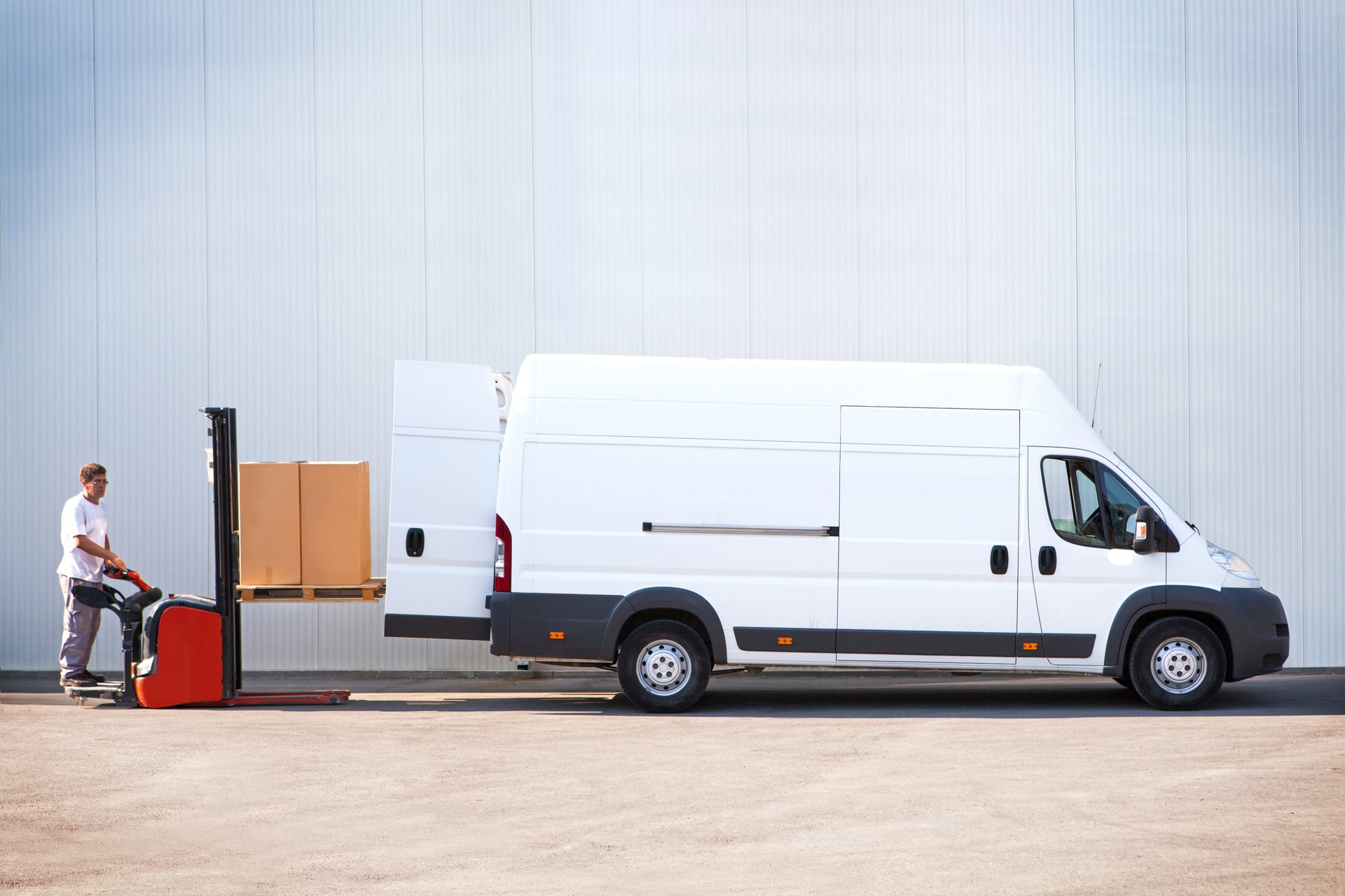 Courier is loading the van with parcels.